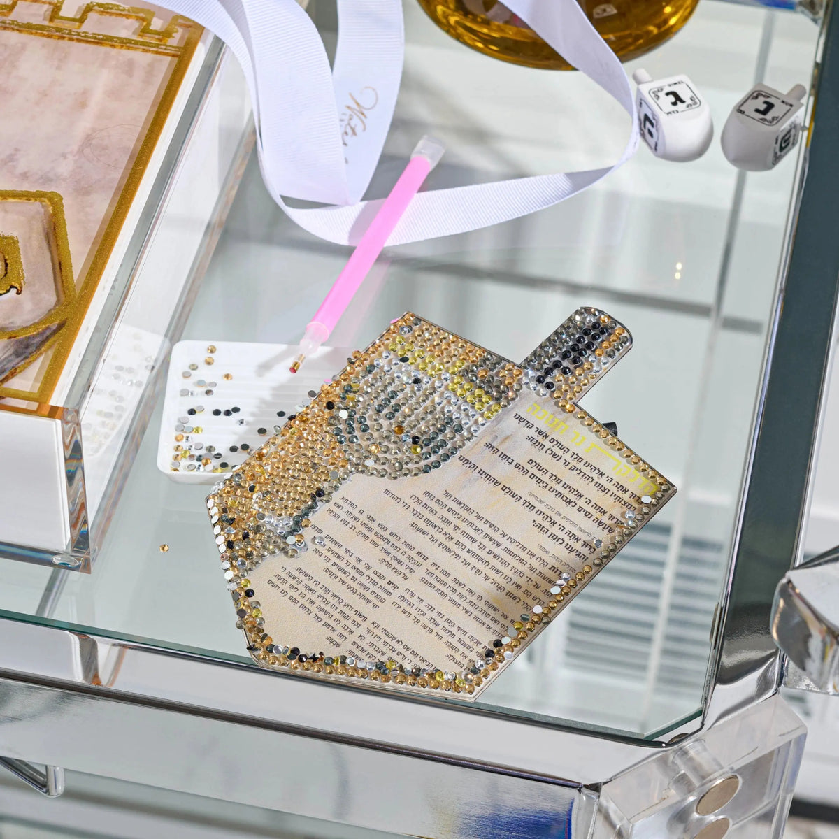 Partly finished Diamond Art dreidel card for Chanukah (חנוכה) with applicator pen, gem tray, and dreidels on a Lucite tray