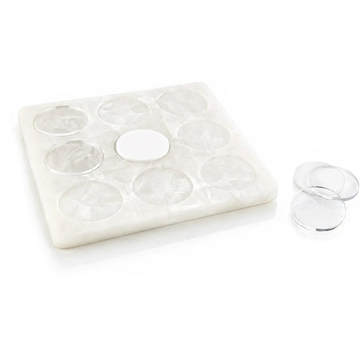 A white resin tic tac toe board with circular recesses and a central oval opening, shown on a white background with three clear round discs beside it.