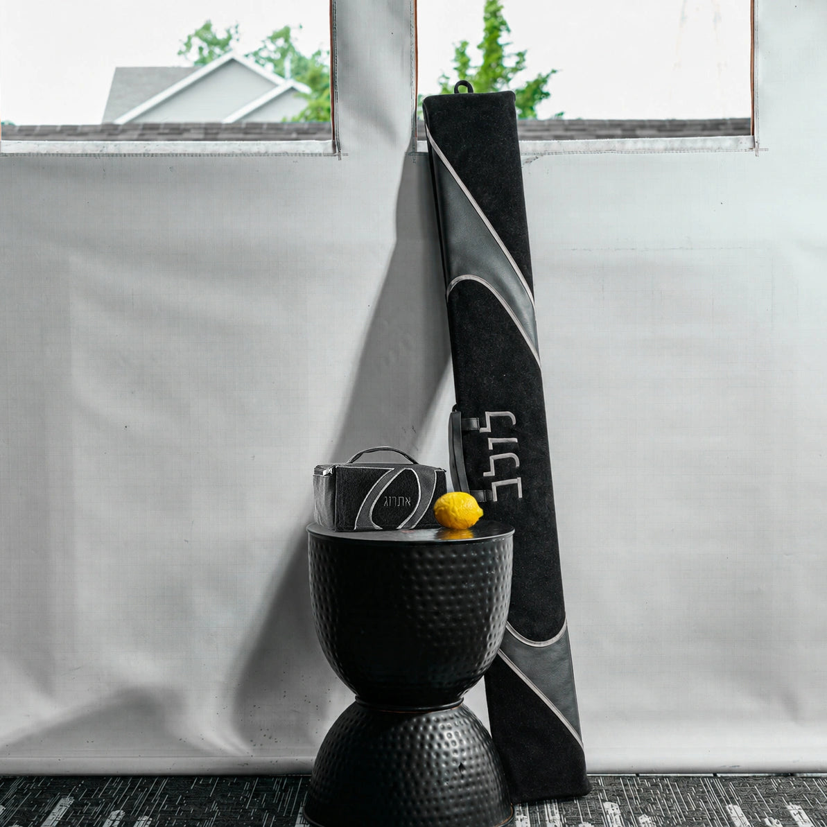 A lifestyle image of a coordinating black and gray faux leather lulav and esrog case for Succos