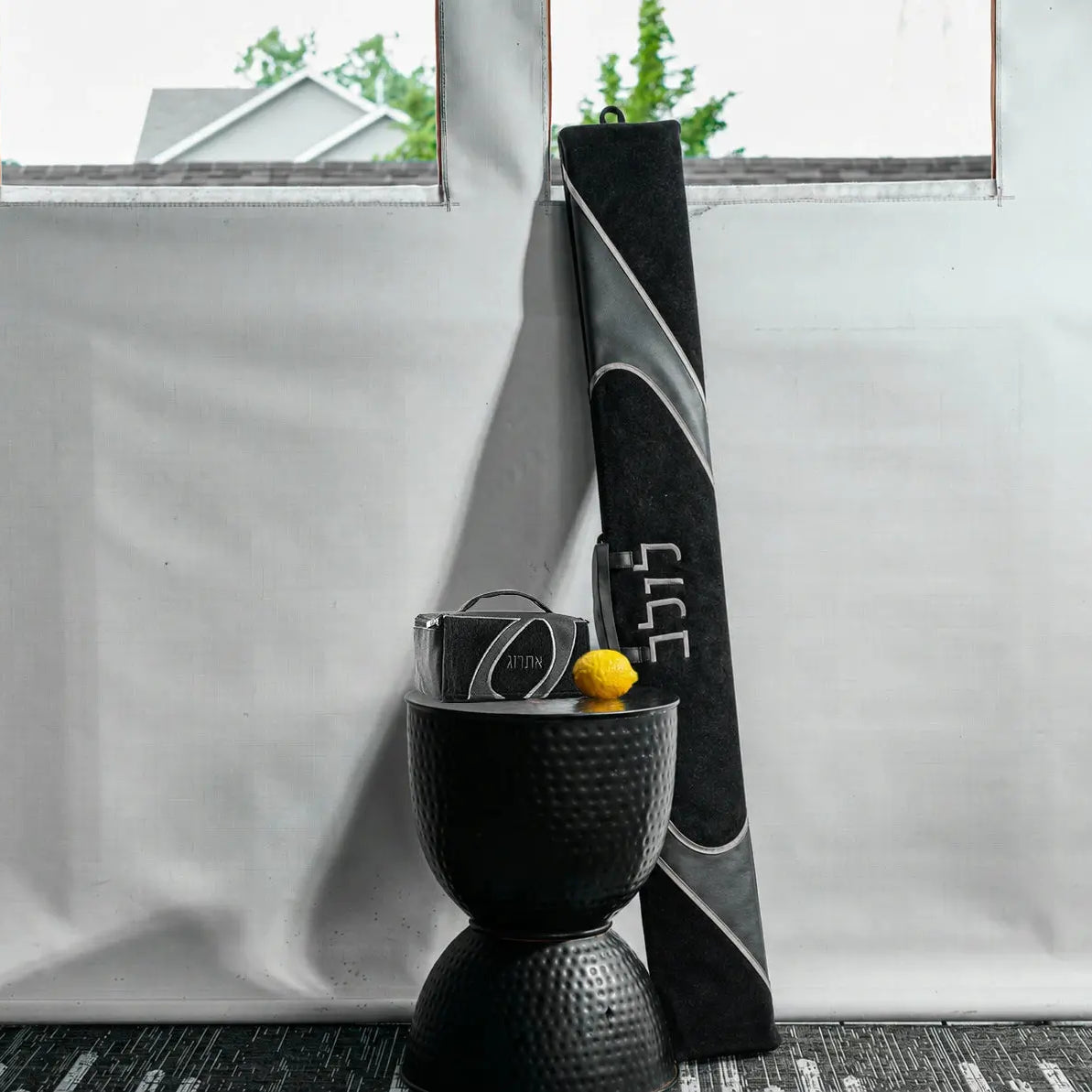 A lifestyle image of a coordinating black and gray faux leather lulav and esrog case for Succos