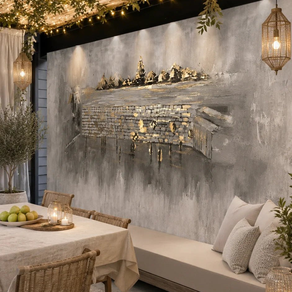 Kosel After Rain vinyl sukkah mural on a full sukkah wall above a linen daybed, lit by string lights and candle lanterns
