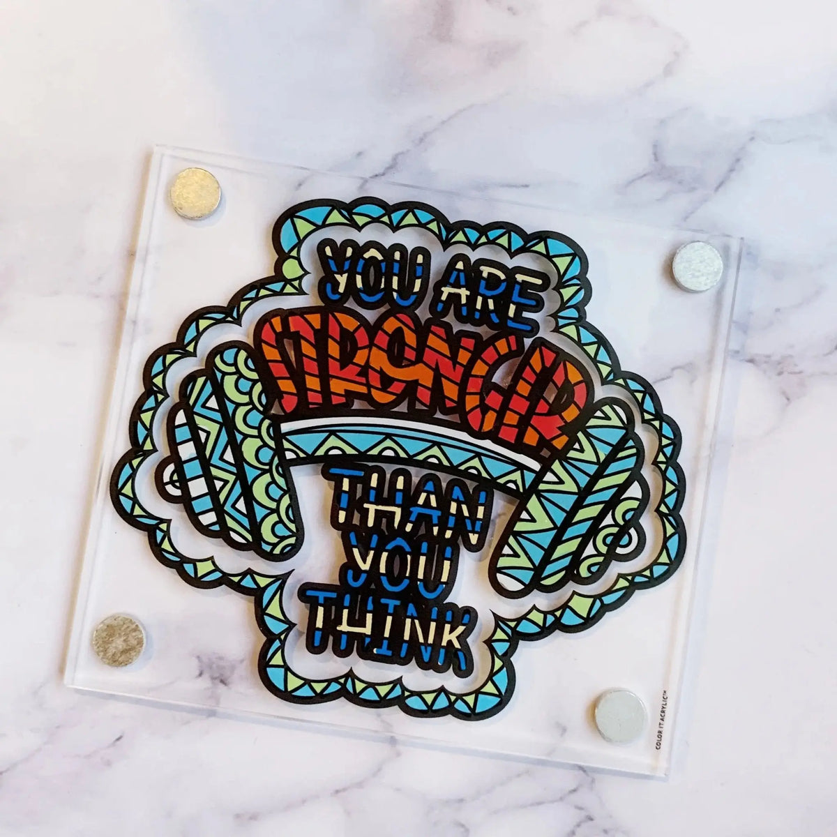 Colorful acrylic quote magnet featuring brain illustration with motivational text, vibrant hand-painted design on marble surface.