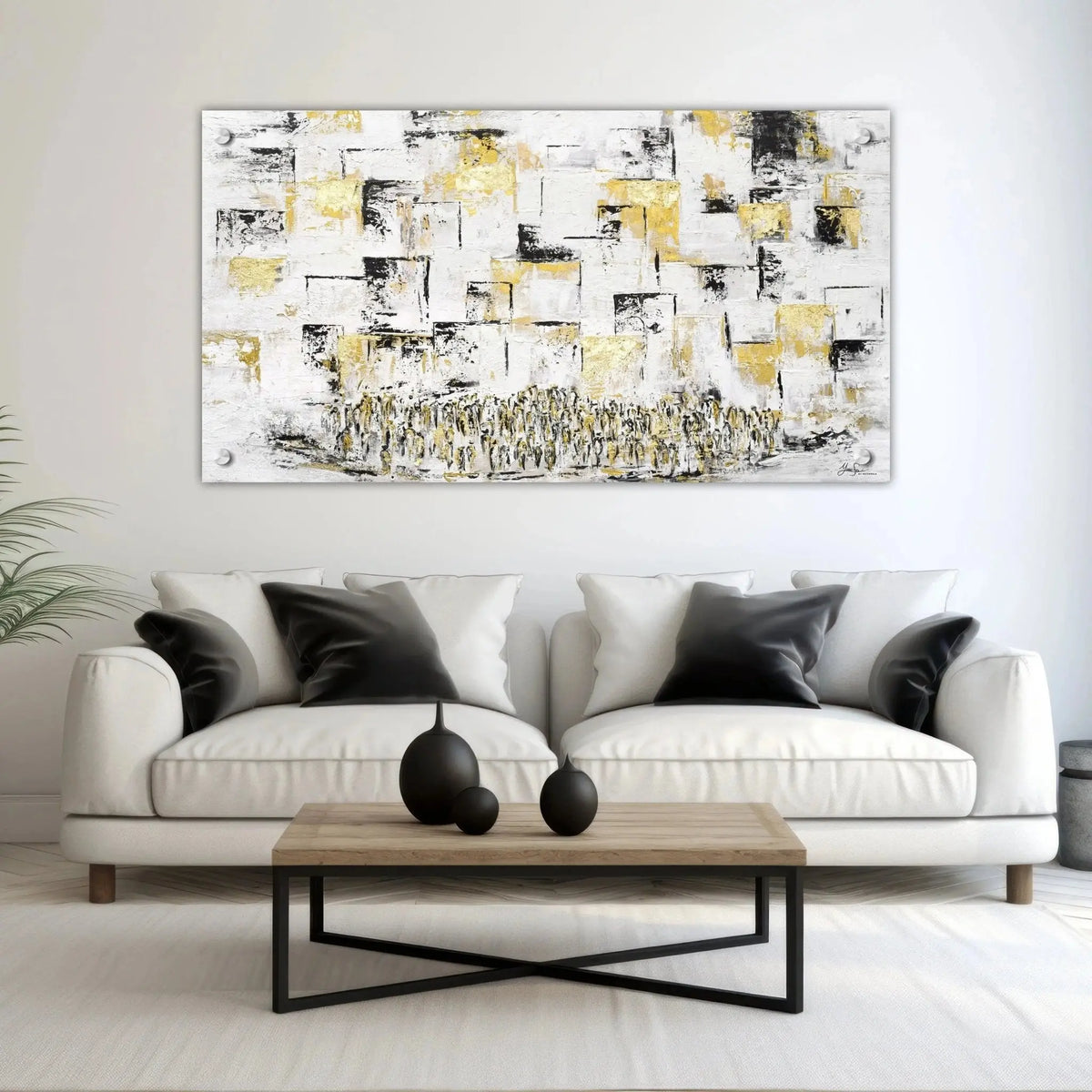 Painted Kosel wall art in black, gold, and white hanging above a light gray sofa in a modern living room with black pillows.