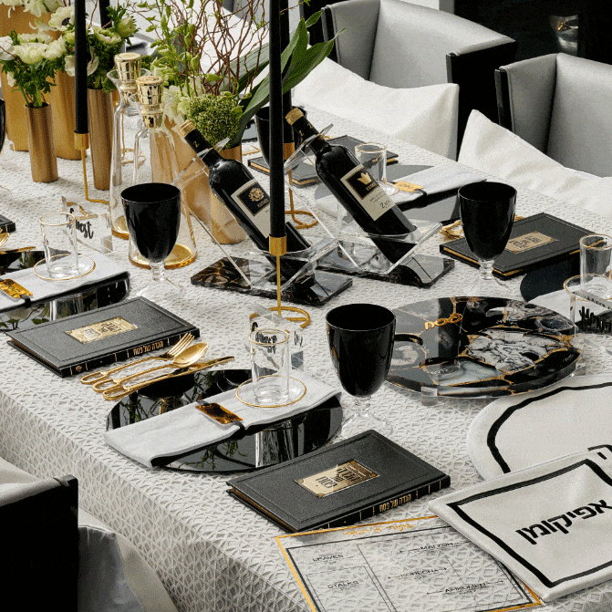 Black agate wine stand displayed on a marble table setting with wine glasses and place settings, showcasing elegant tableware for Shabbat and holiday entertaining.