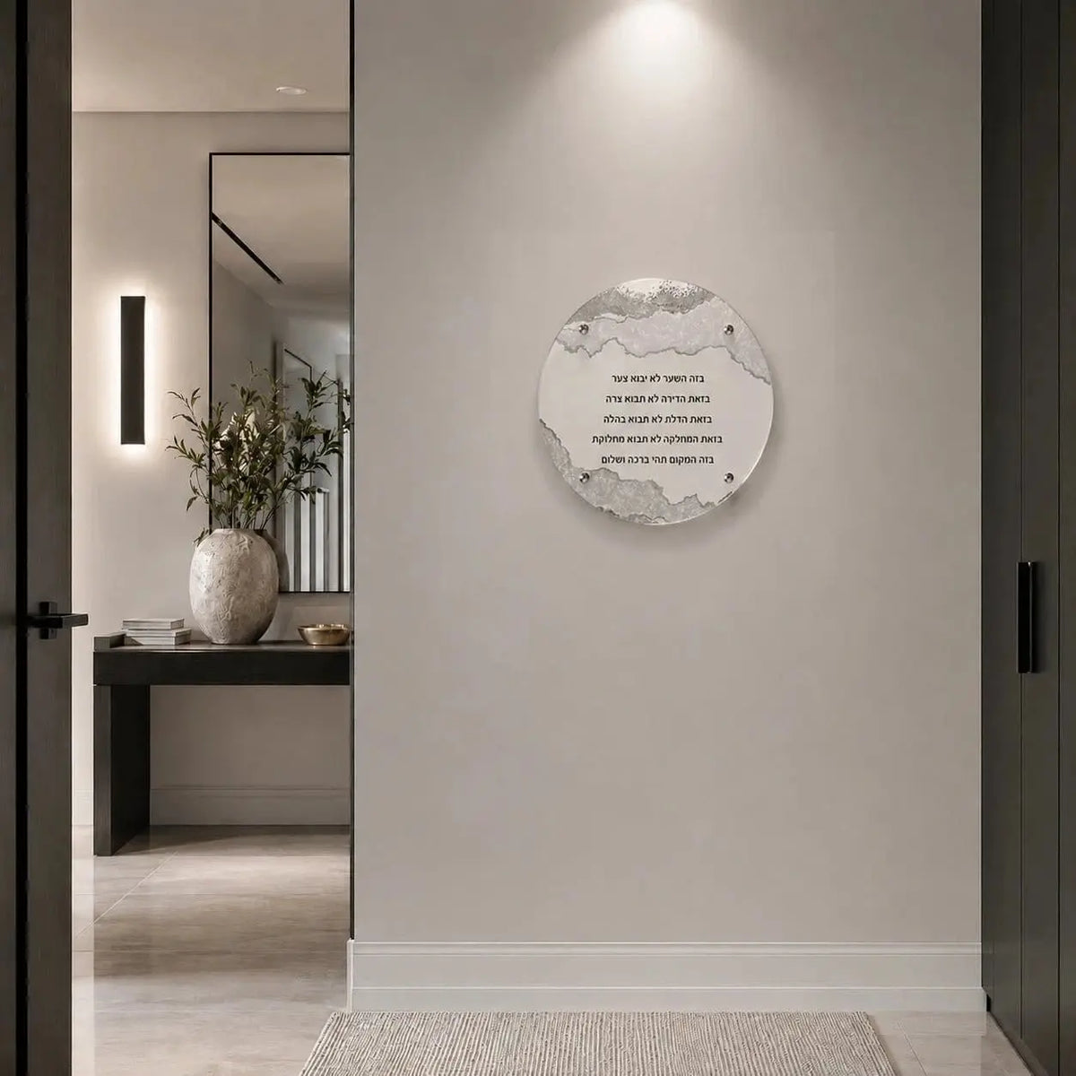 A circular wall art print featuring BIRCHAS HABAYIS displayed on a light beige wall in a modern, minimalist hallway with a mirror and console table visible in the background.