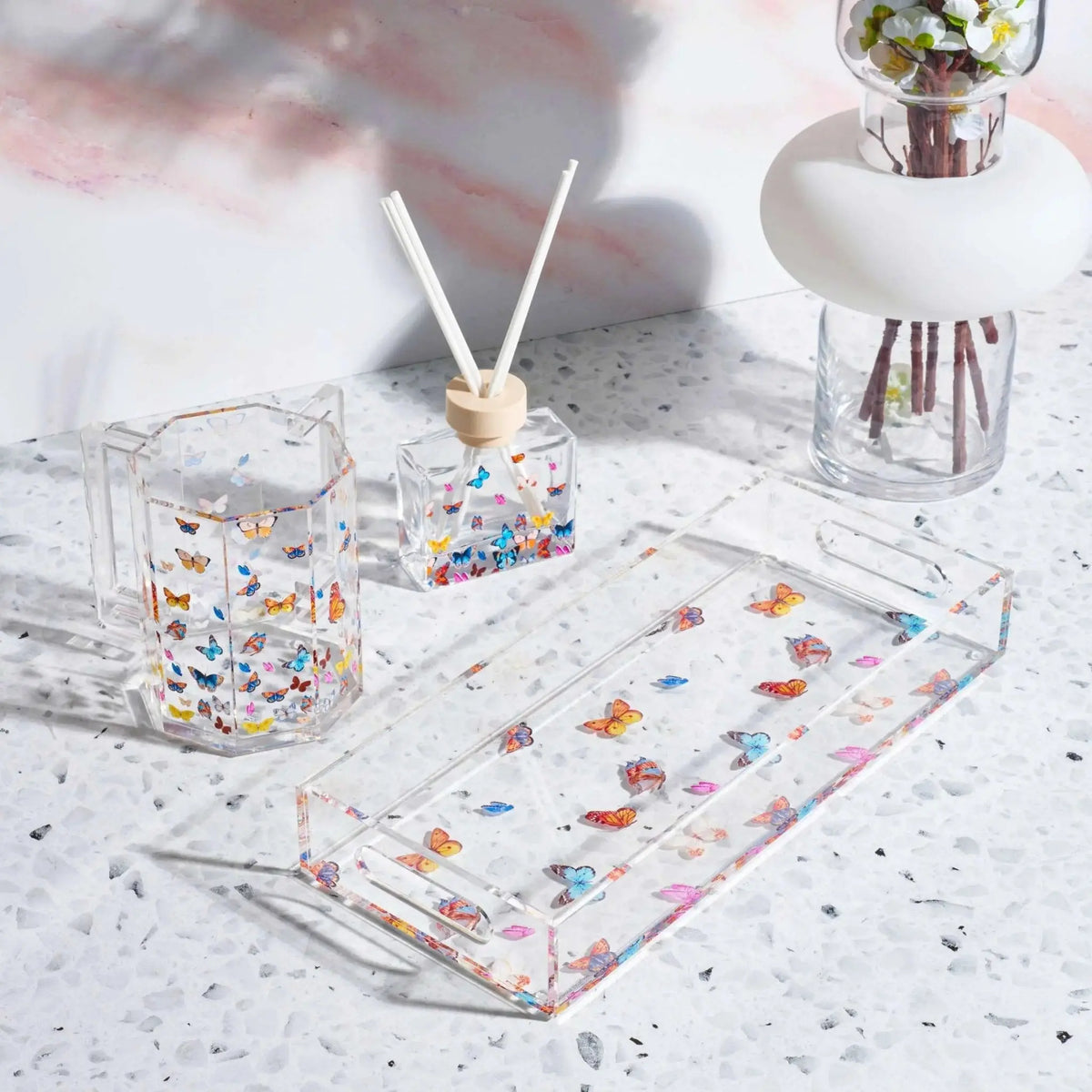 Waterdale Collection butterfly washing cup displayed with matching accessories on white speckled surface, featuring colorful butterfly design.