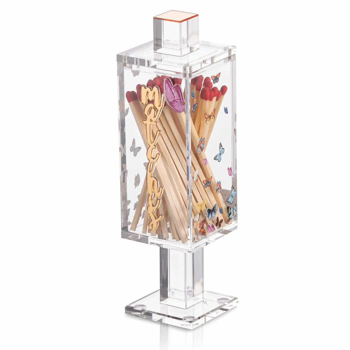 Clear glass butterfly match holder with decorative gold and pink butterfly design, filled with colorful matches, standing on square base