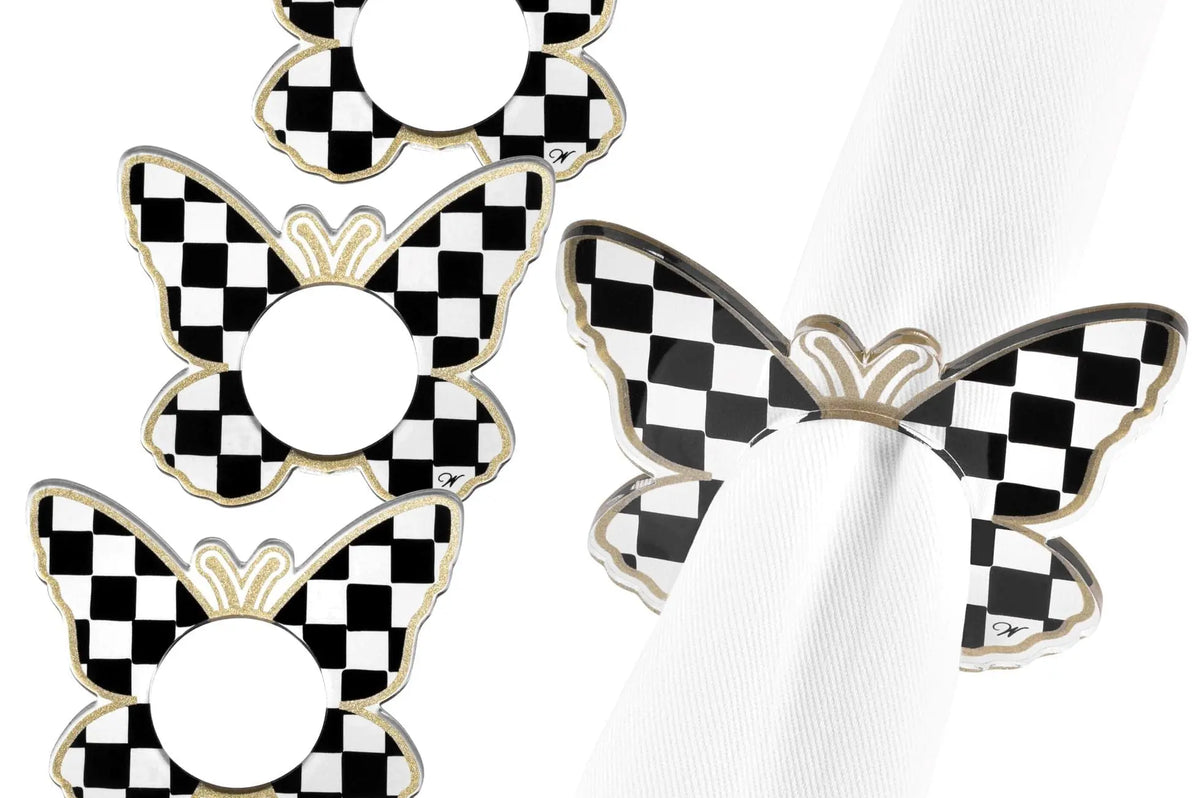 Set of four black and white checkered onyx butterfly napkin rings arranged on white fabric background.