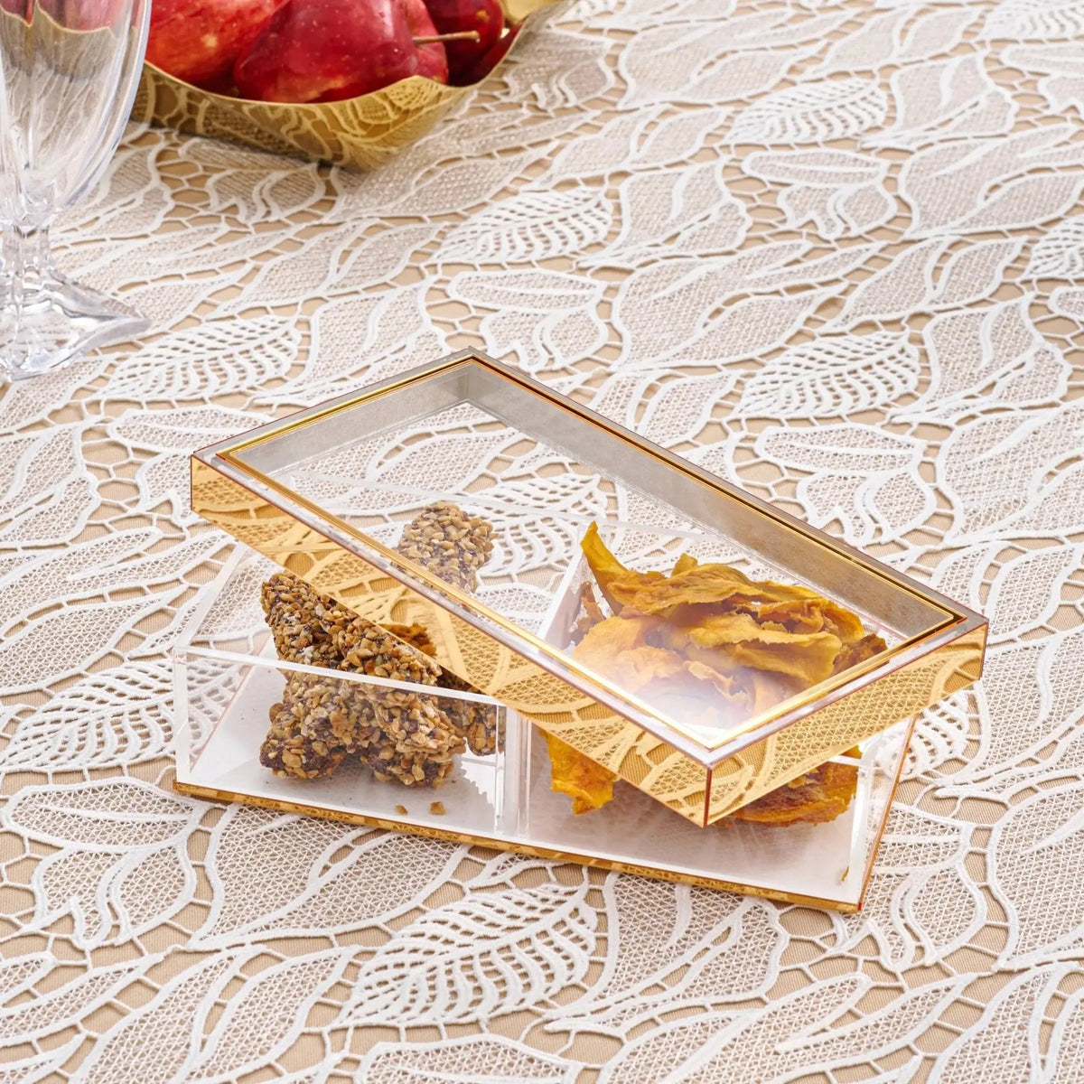 Gold-trimmed removable sectional tray with compartments holding nuts and dried fruit on cream lace tablecloth, perfect for entertaining and holiday hosting.