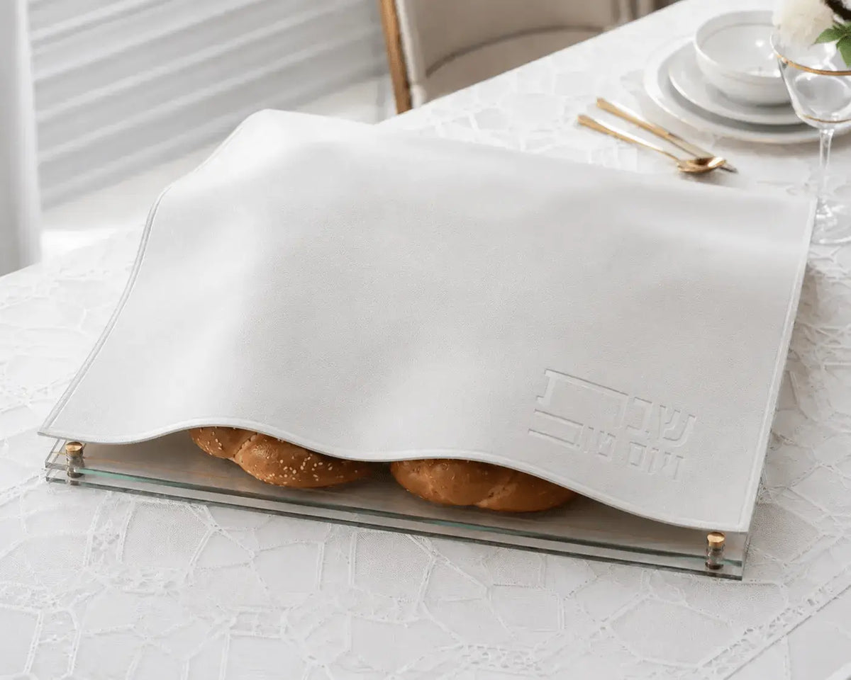 White embossed leather challah cover with gold trim, displayed open to show interior, perfect for Shabbat table settings.
