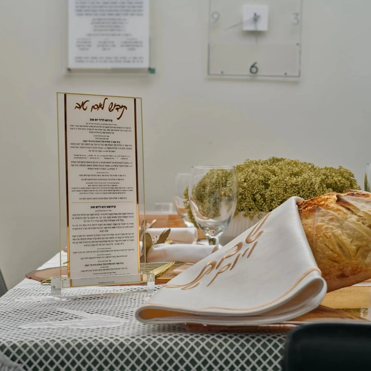Classic Kiddush Yom Tov lucite card in gold and silver, displayed with fresh flowers and challah bread on table.
