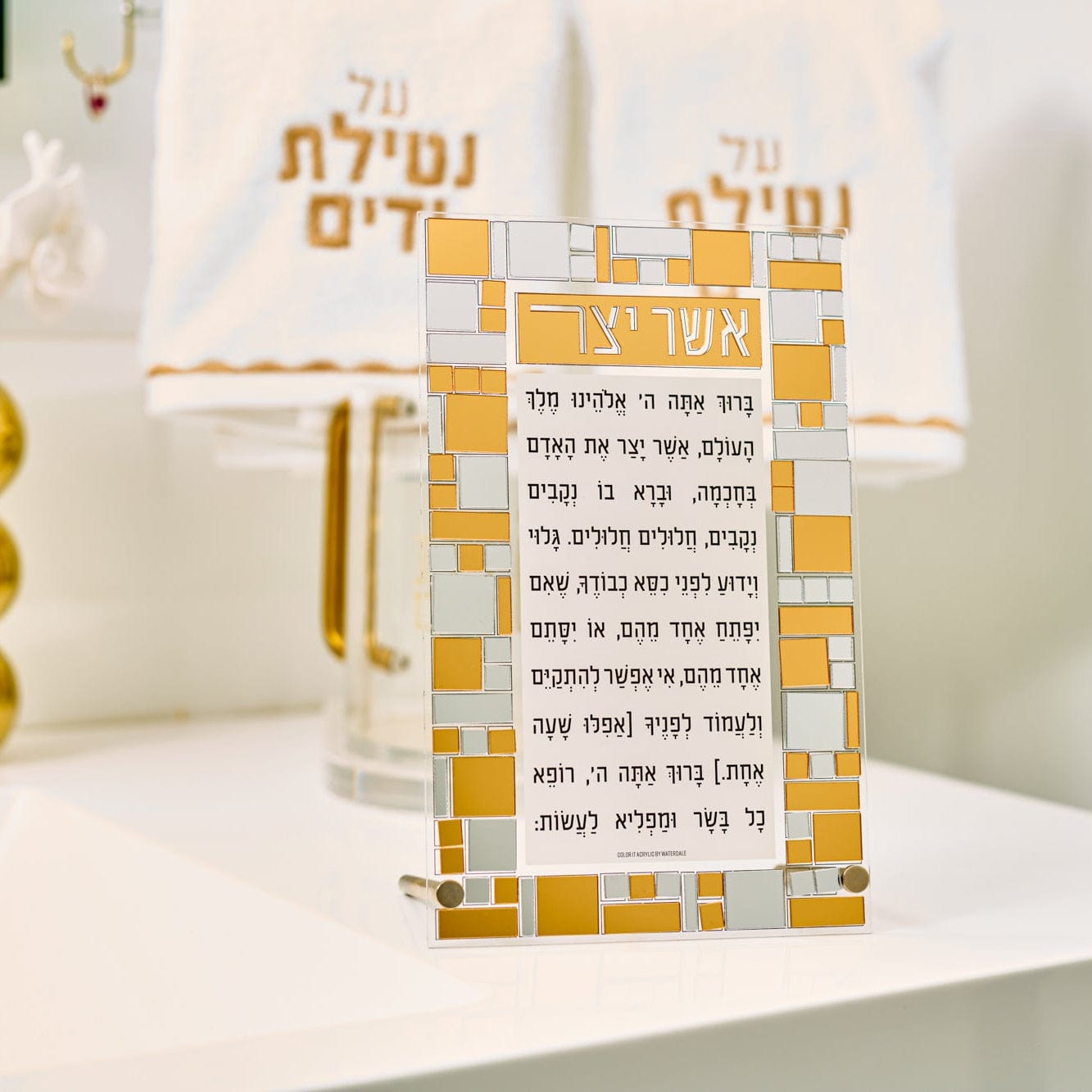 Color-It acrylic mosaic Asher Yatzar tabletop with Hebrew prayer text and gold mosaic border design displayed on a countertop.