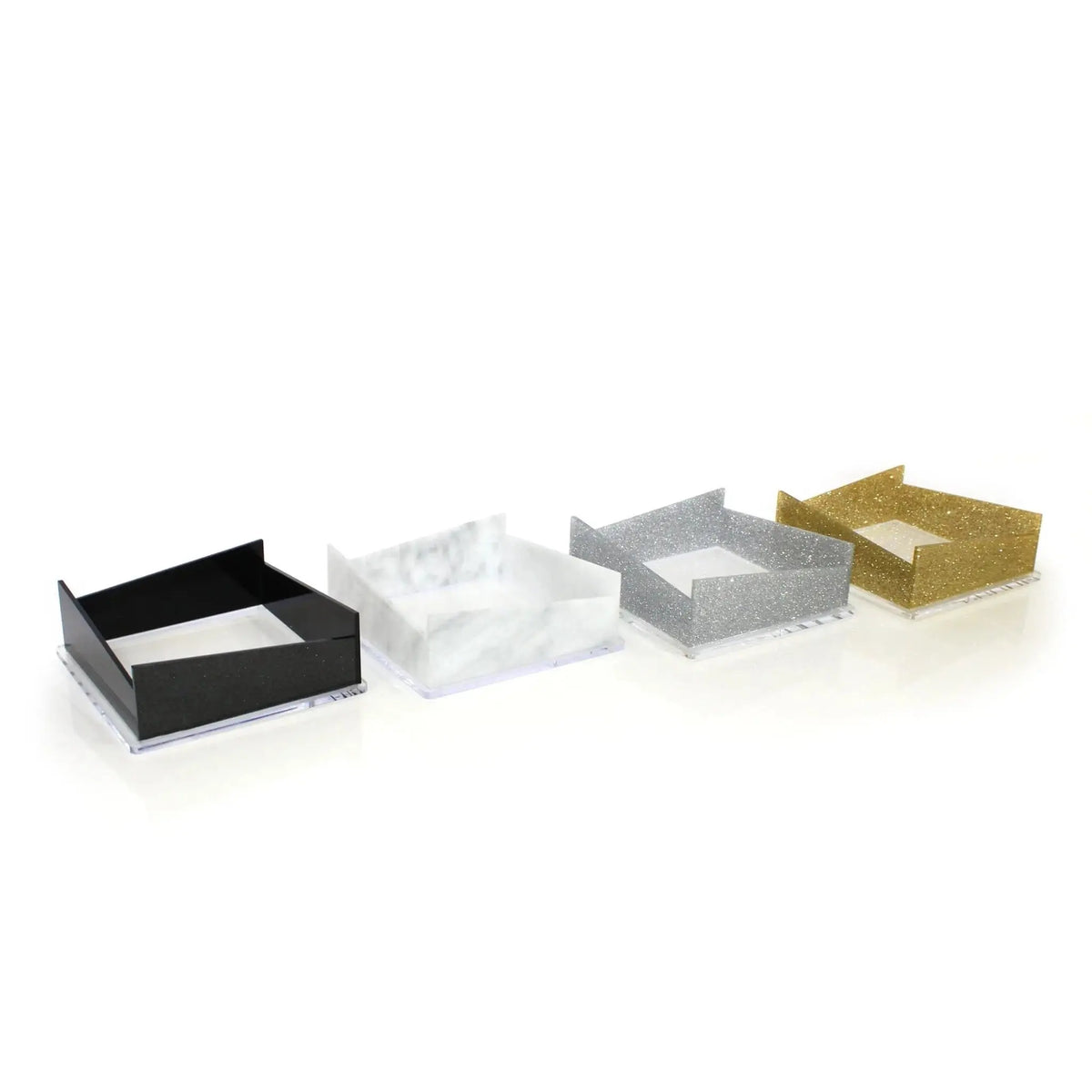 Diagonal napkin holder in black, clear, silver glitter, and gold glitter finishes arranged in a row displaying color options.