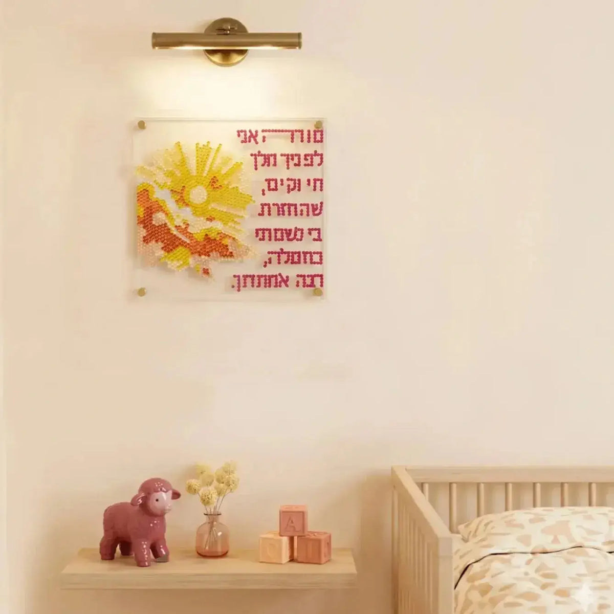 Diamond Art Modeh Ani wall art in acrylic with yellow floral design and Hebrew text, displayed above nursery shelf.