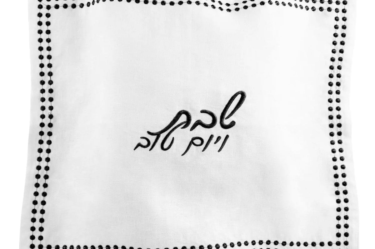 White linen challah cover with dotted border design and Hebrew embroidery detail by Waterdale Collection.
