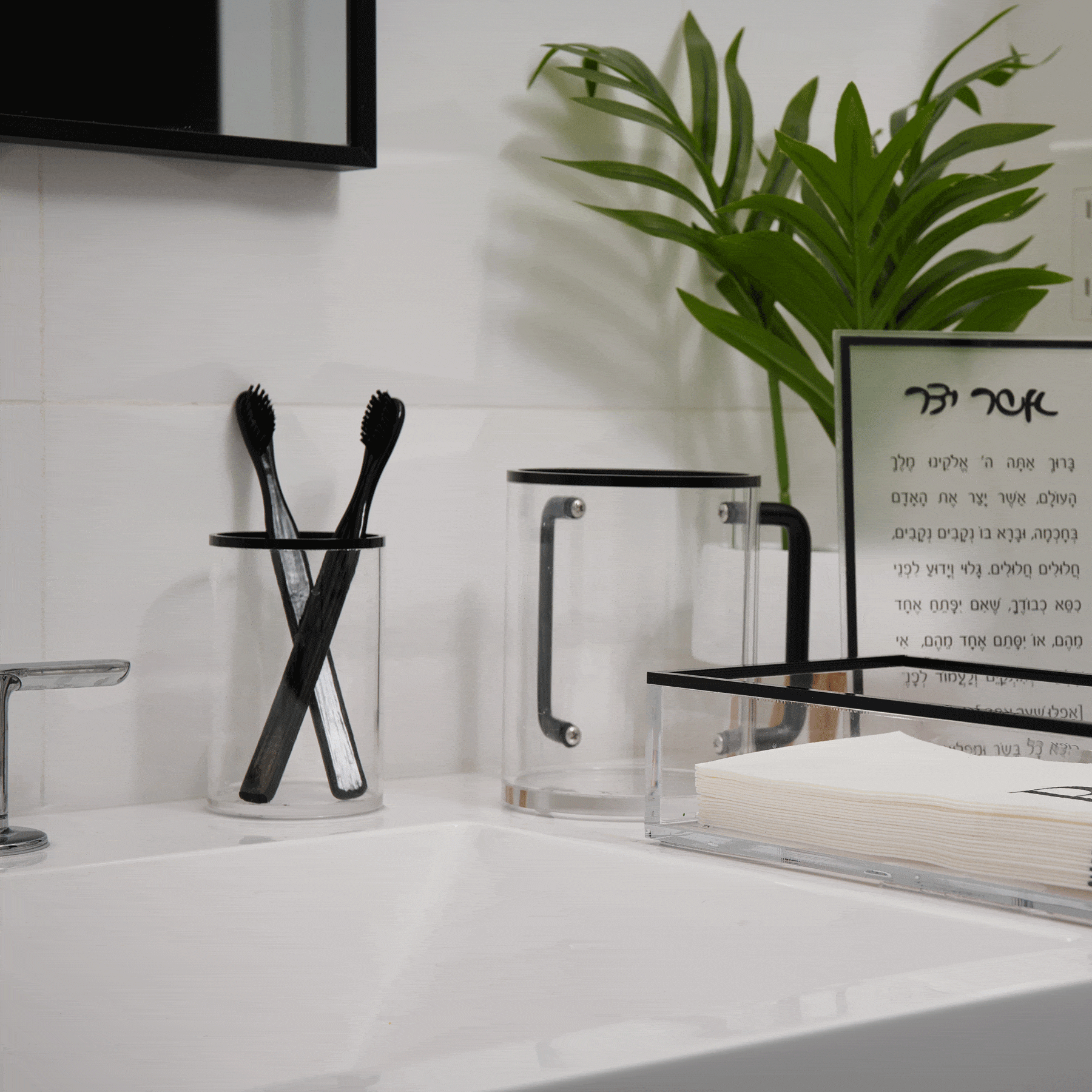 Black stainless steel Edge Cup displayed on white bathroom vanity next to toothbrushes and plants