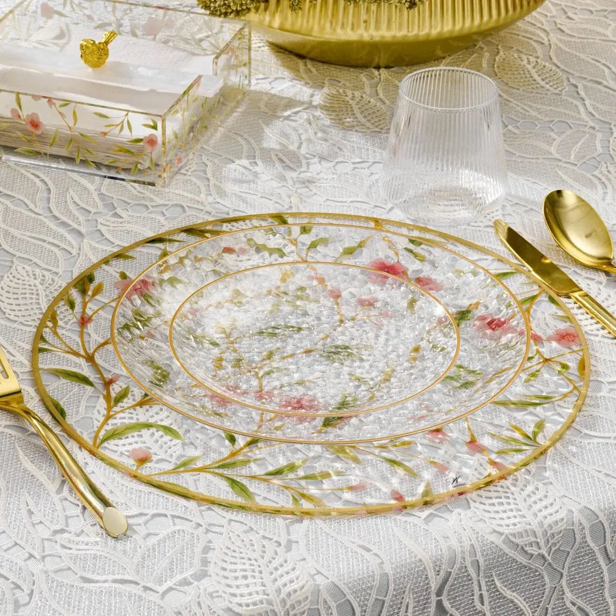 Floral Bird Charger plate with delicate pink and green botanical design on cream background, featuring gold rim and matching gold utensils on white damask tablecloth.