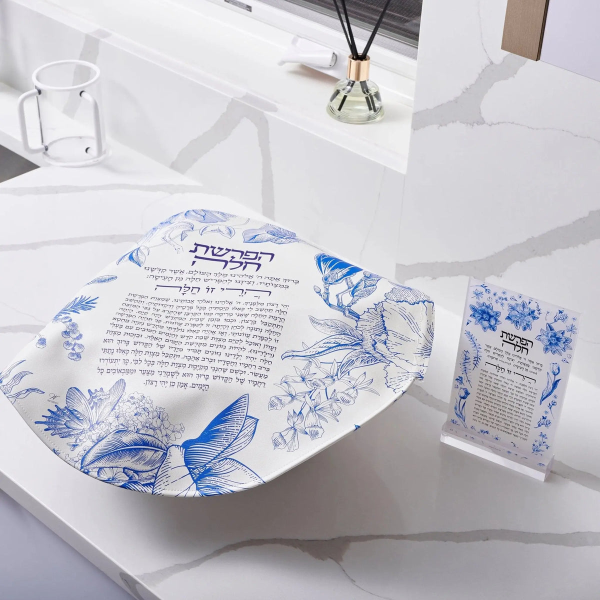 French Toile Hafrashas Challah Cover in blue and white leather displayed on white desk with matching cup holder