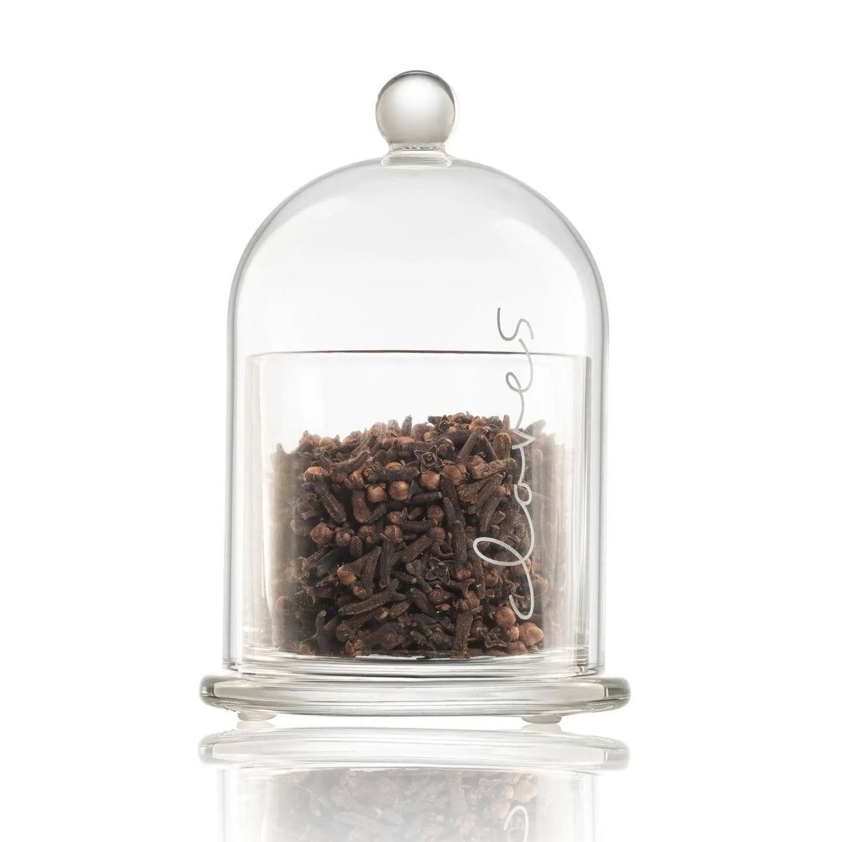 Glass Cloche Besamim from Waterdale Collection with dark spices inside, featuring a clear dome and metal base for Shabbat and Havdalah use.