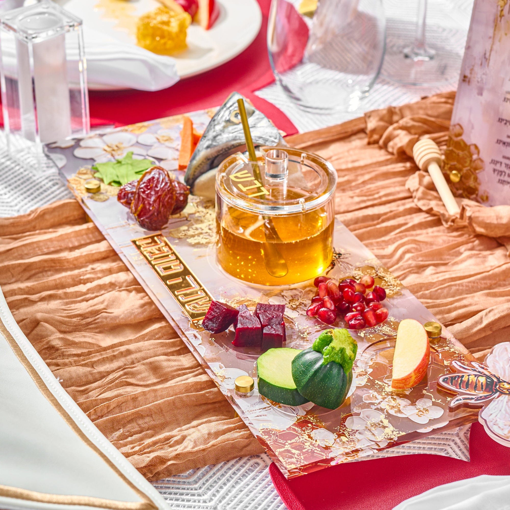 Honeycomb Simanim Tray with honey dish, fish head, and other items on top of it in a Rosh Hashanah table setting
