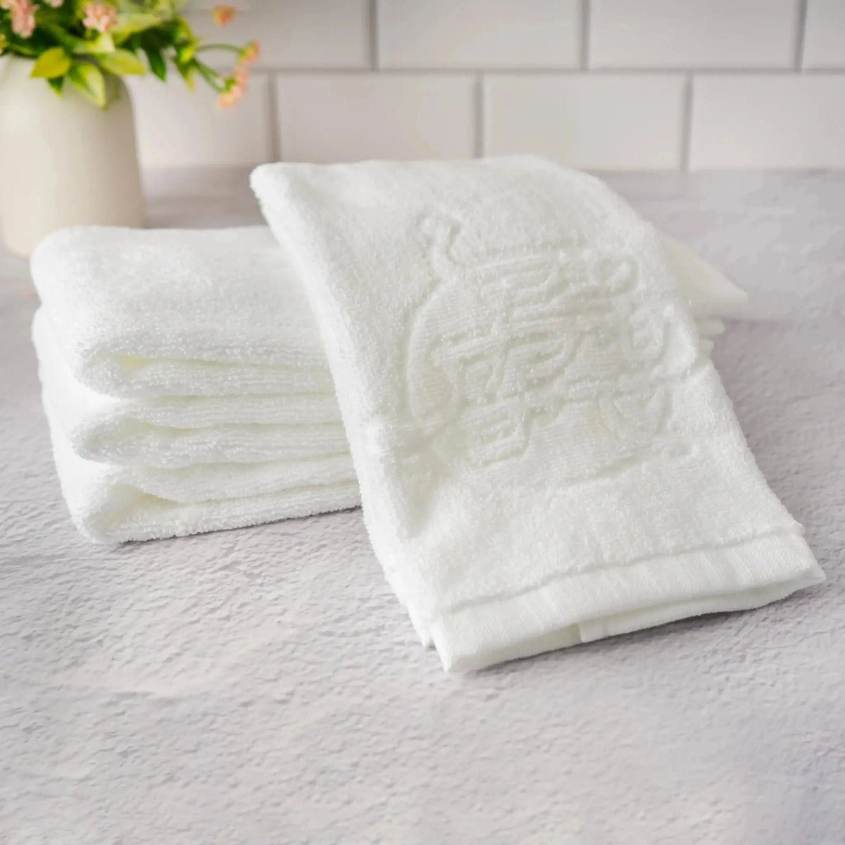 Two white al netillas yadayim towels on a textured surface