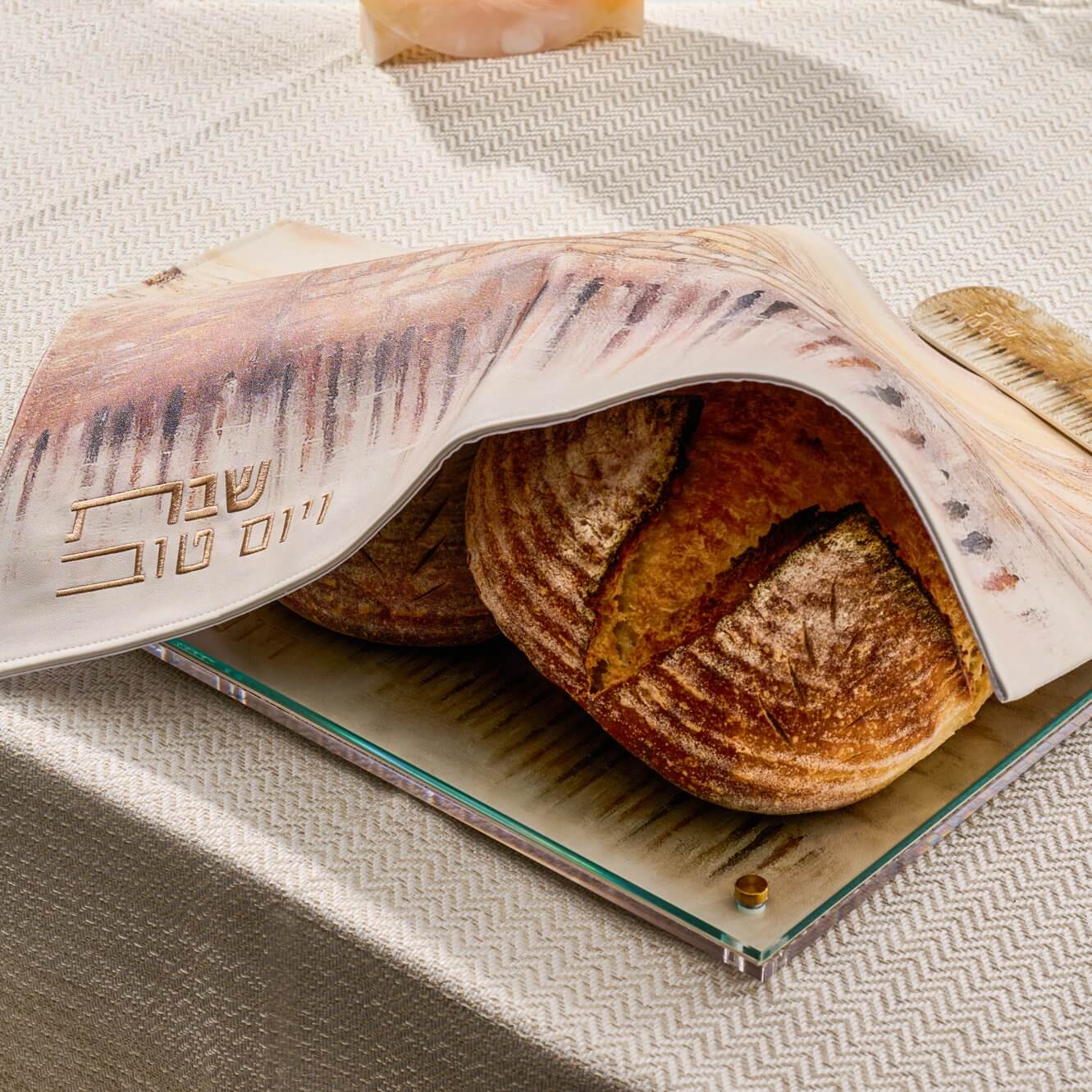 Jerusalem Taupe Challah Cover with artistic skyline design and gold Hebrew 'Shabbat V’Yom Tov' embroidery.