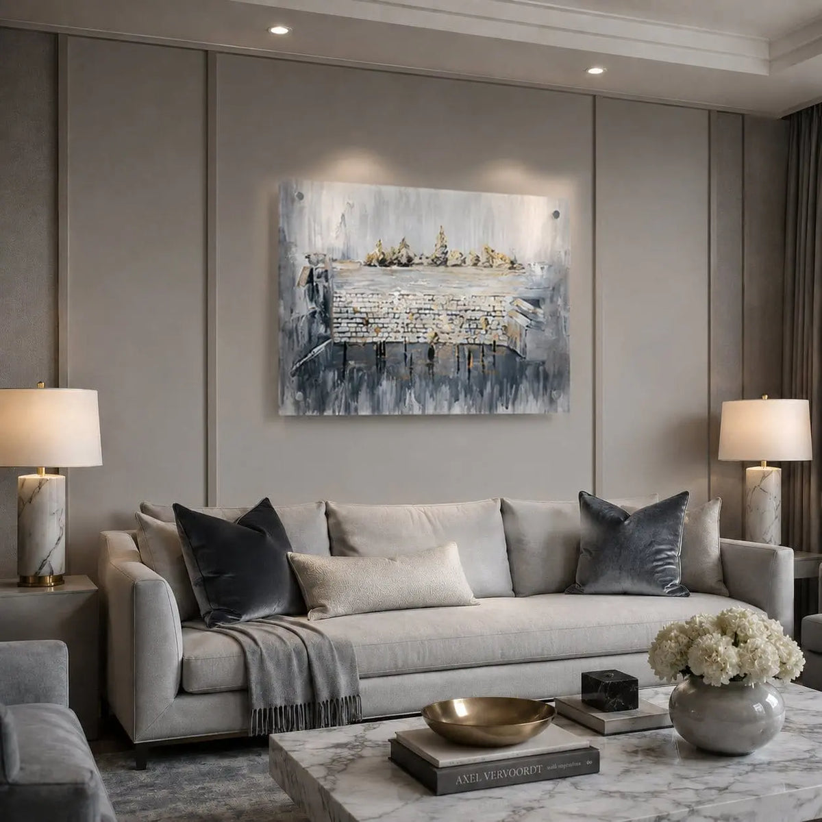 A modern living room featuring a large abstract canvas painting with blue, gray, and white tones of th ekosel , hung on a gray paneled wall above a light gray sofa.