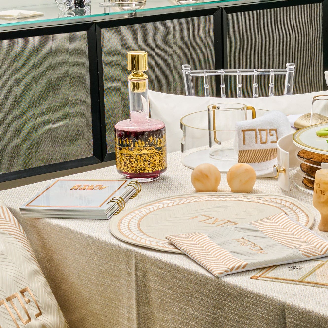 Kosel at Winter Pesach Collection featuring elegant red and gold Jerusalem skyline wine decanter, coordinated Pesach table setting with matzah cover and Seder plate, luxury Judaica for Passover entertaining, modern Jewish holiday décor.