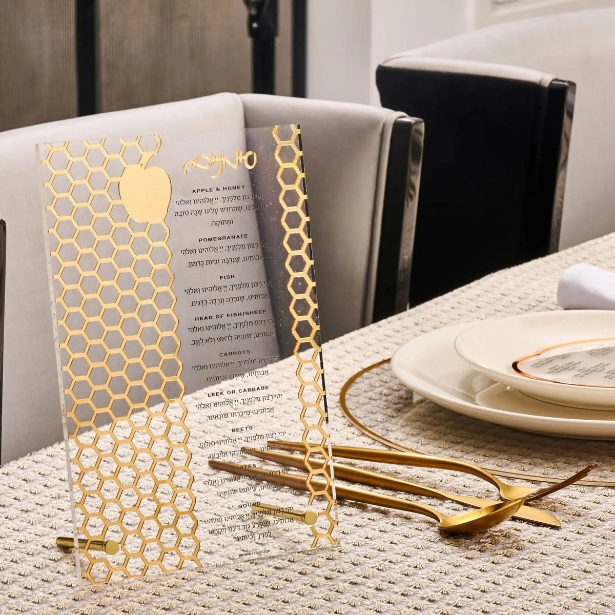 Gold laser-cut simanim (סימנים) tabletop on a Rosh Hashana place setting