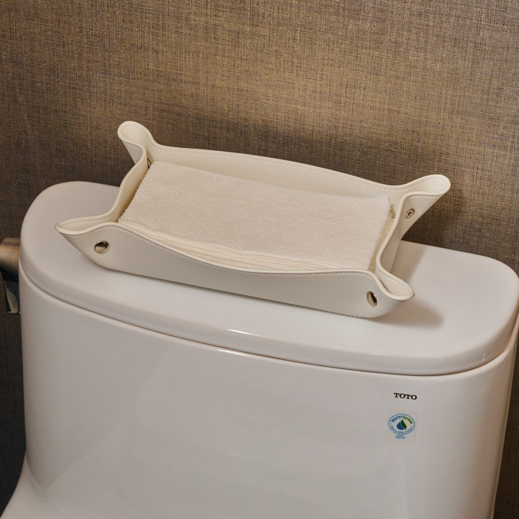 White Leather Shabbos Toilet Paper holder displayed on a toilet tank of a modern bathroom