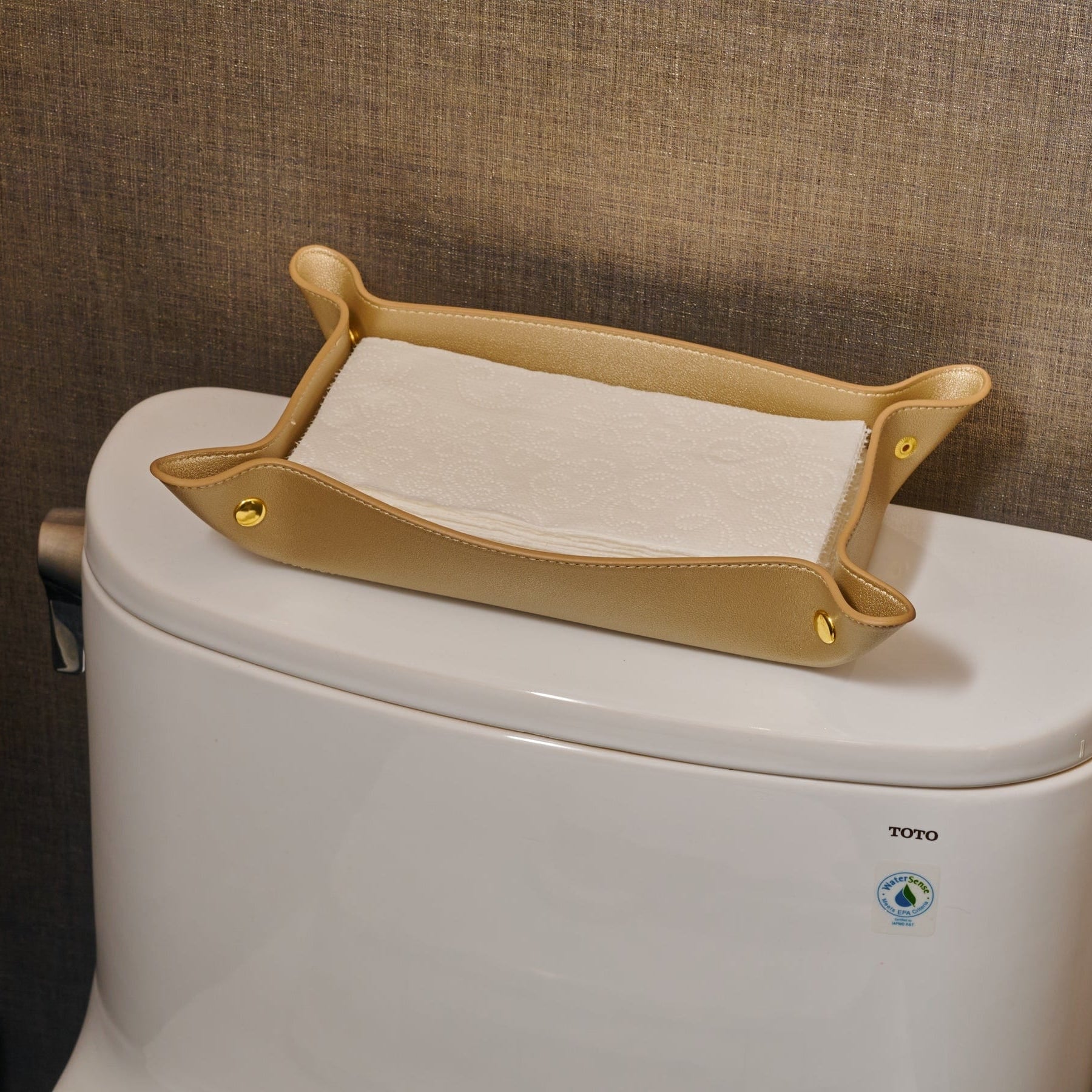 Gold Leather Shabbos Toilet Paper Holder displayed on a toilet tank in a modern bathroom
