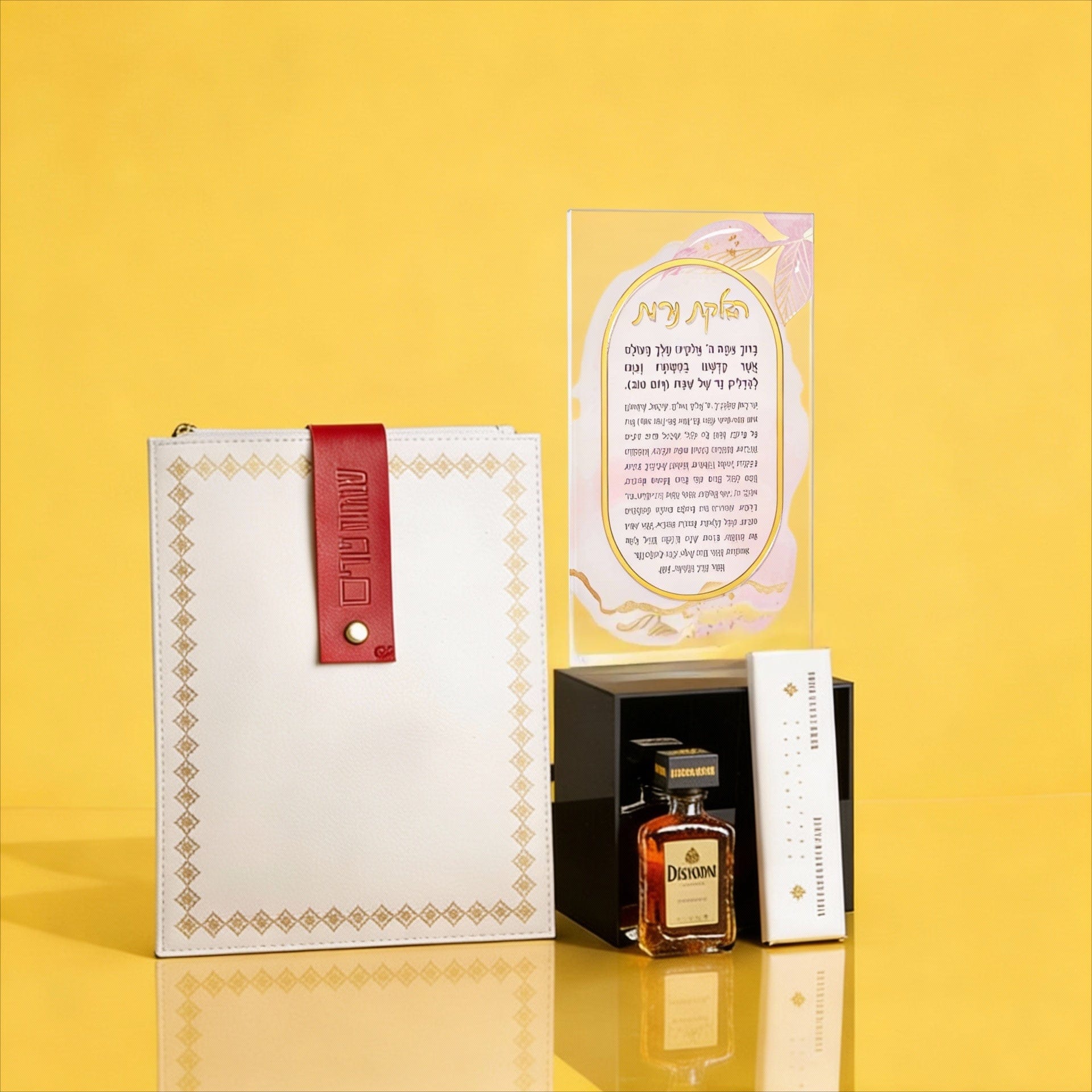 Luxury Mishloach Manot gift set featuring a watercolor Hadlokas Neiros card in a lucite stand, a white leatherette pouch with a red strap, a mini Disaronno liqueur, and dark chocolate.