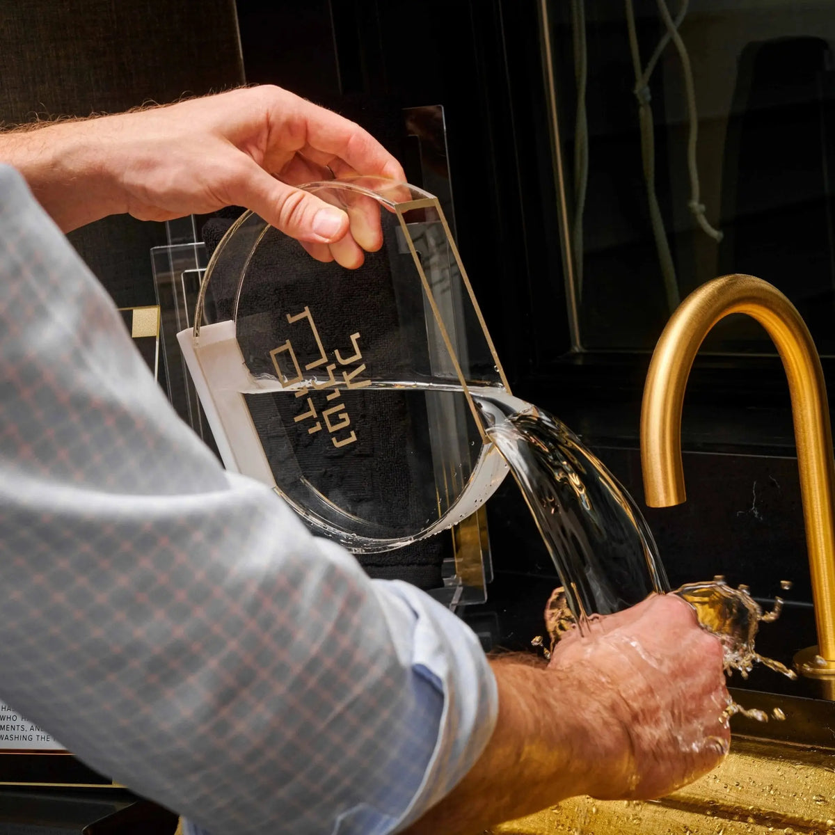 Gold modern netilas yadayim washing cup displayed on bathroom vanity with contemporary design and polished finish