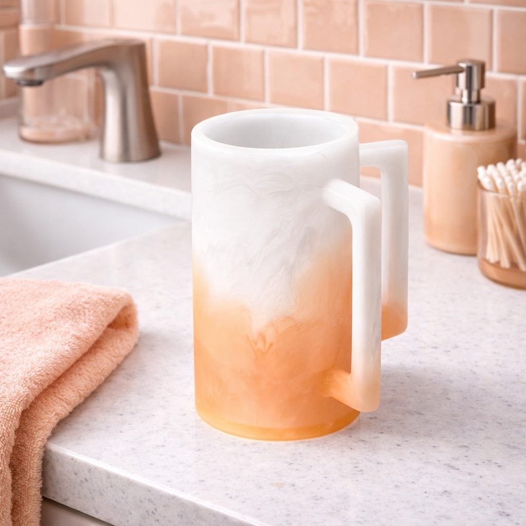 Ombre resin washing cup with a white-to-peach gradient finish, displayed on a bathroom countertop