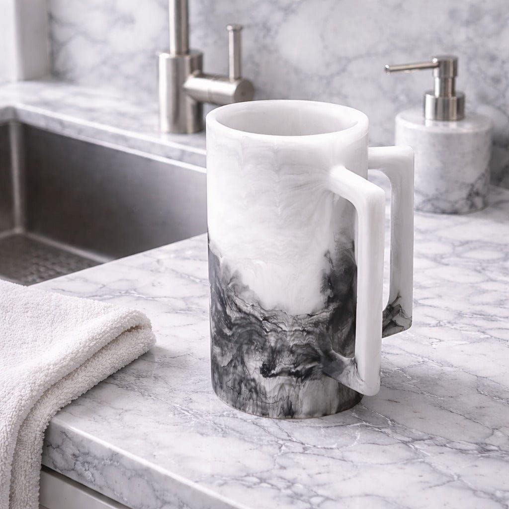 Ombre resin washing cup with white and charcoal marble-style finish, displayed on a marble bathroom countertop