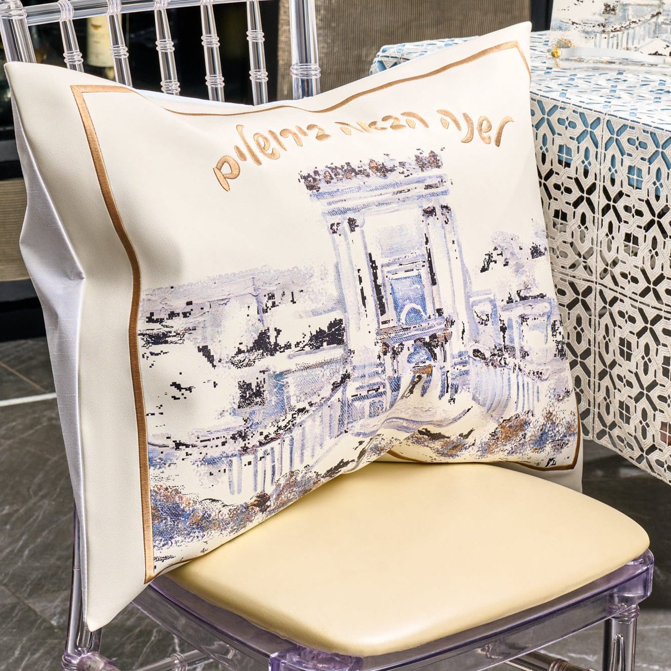 Painted Bais Hamikdash Pesach set with artistic Jerusalem scene and gold Hebrew lettering, displayed on a chair for Seder table décor.