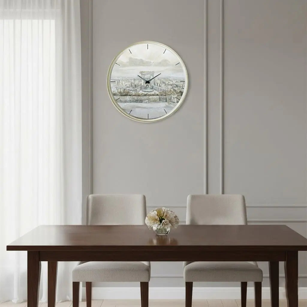 Round painted wall clock featuring a serene landscape design by Yonatan, displayed above a wooden dining table in a modern home interior