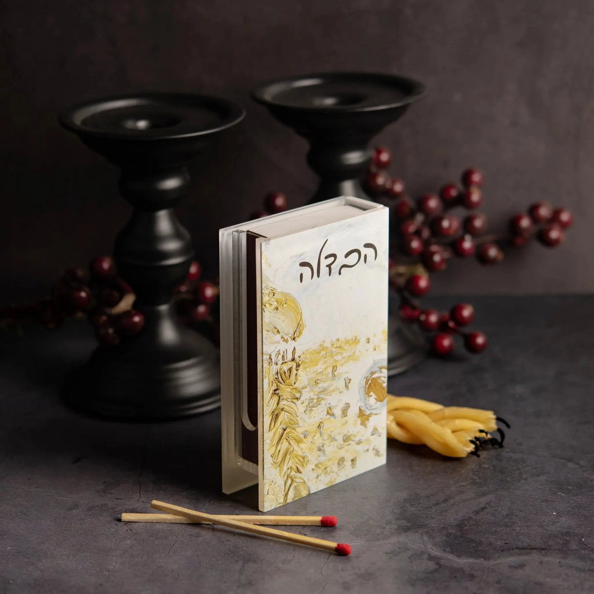 Painted Gold Havdalah Matchbox Holder with intricate floral design, displayed with black candlesticks, matches, and decorative beads on dark surface.