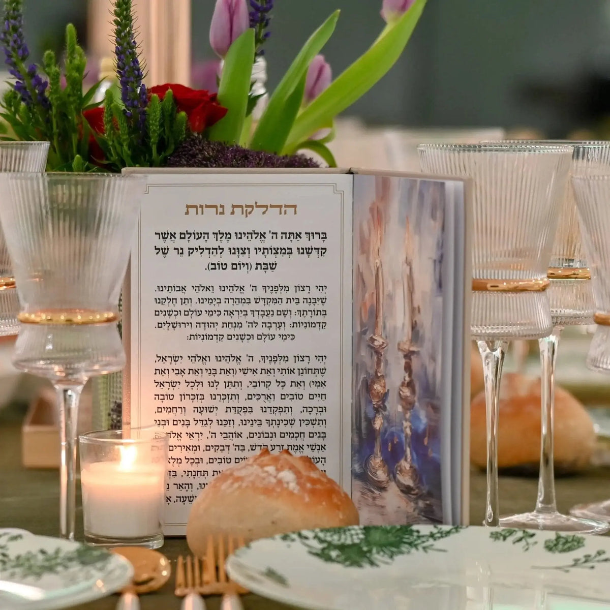Painted leather Hadlokas Neiros booklet displayed on table with candles, flowers, and place settings for candle-lighting ceremony.