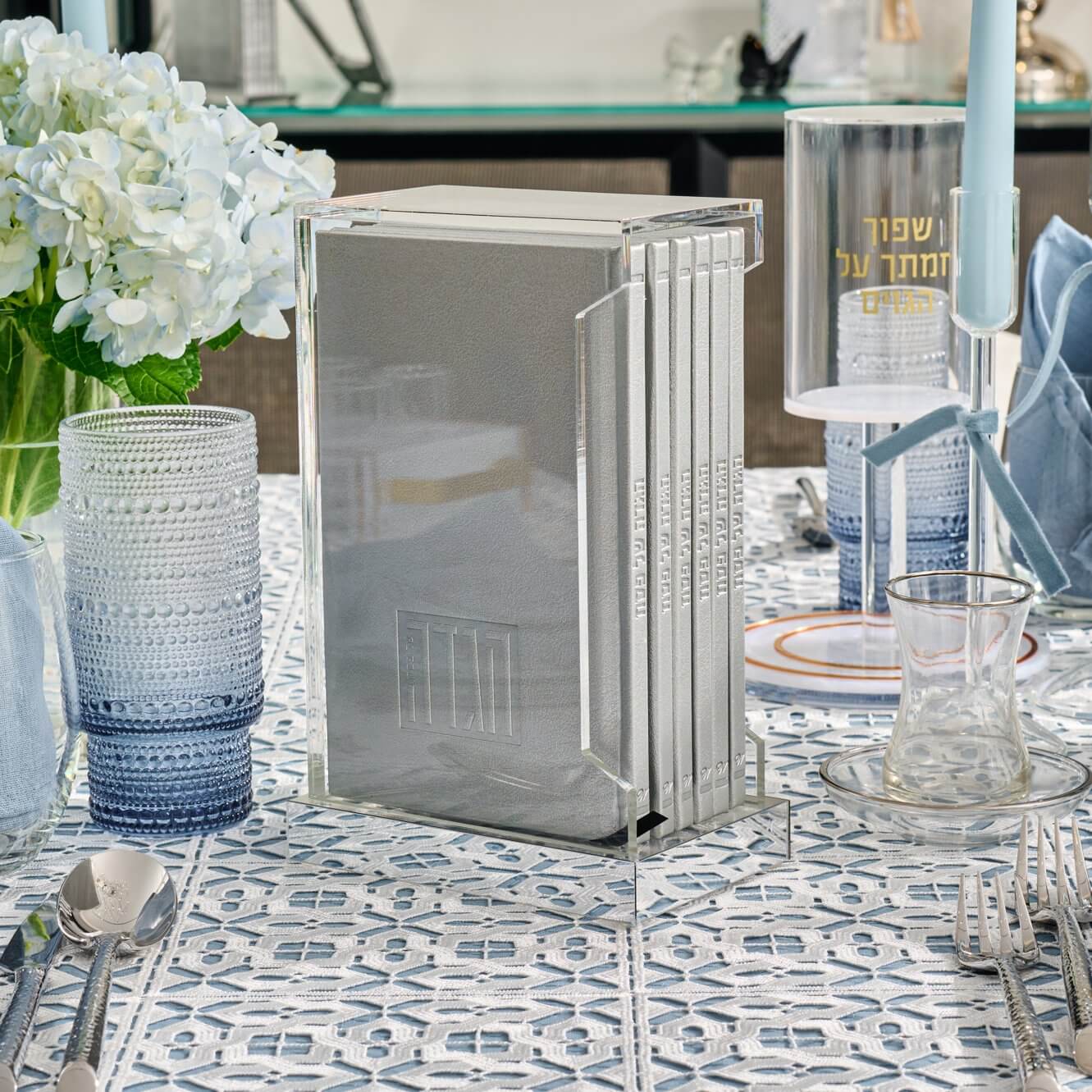 Painted Shabbos and Yom Tov Zemiros Bencher Set in a clear lucite holder with a gold mirror base, elegant Judaica table decor.