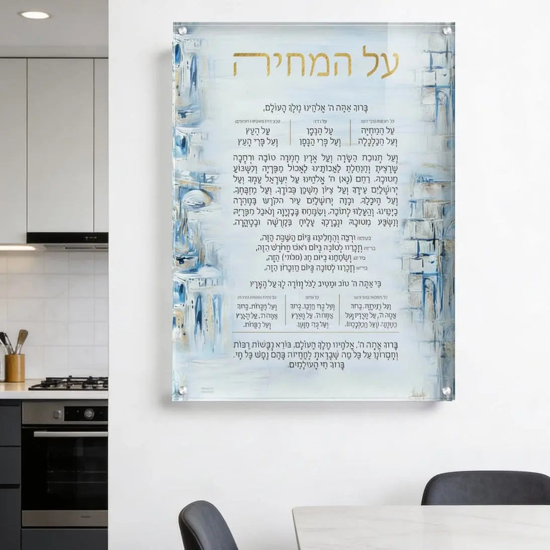 Painted Yosefa Kosel Al Hamichya blessing print with blue watercolor border design, mounted as floating wall art in modern kitchen setting.