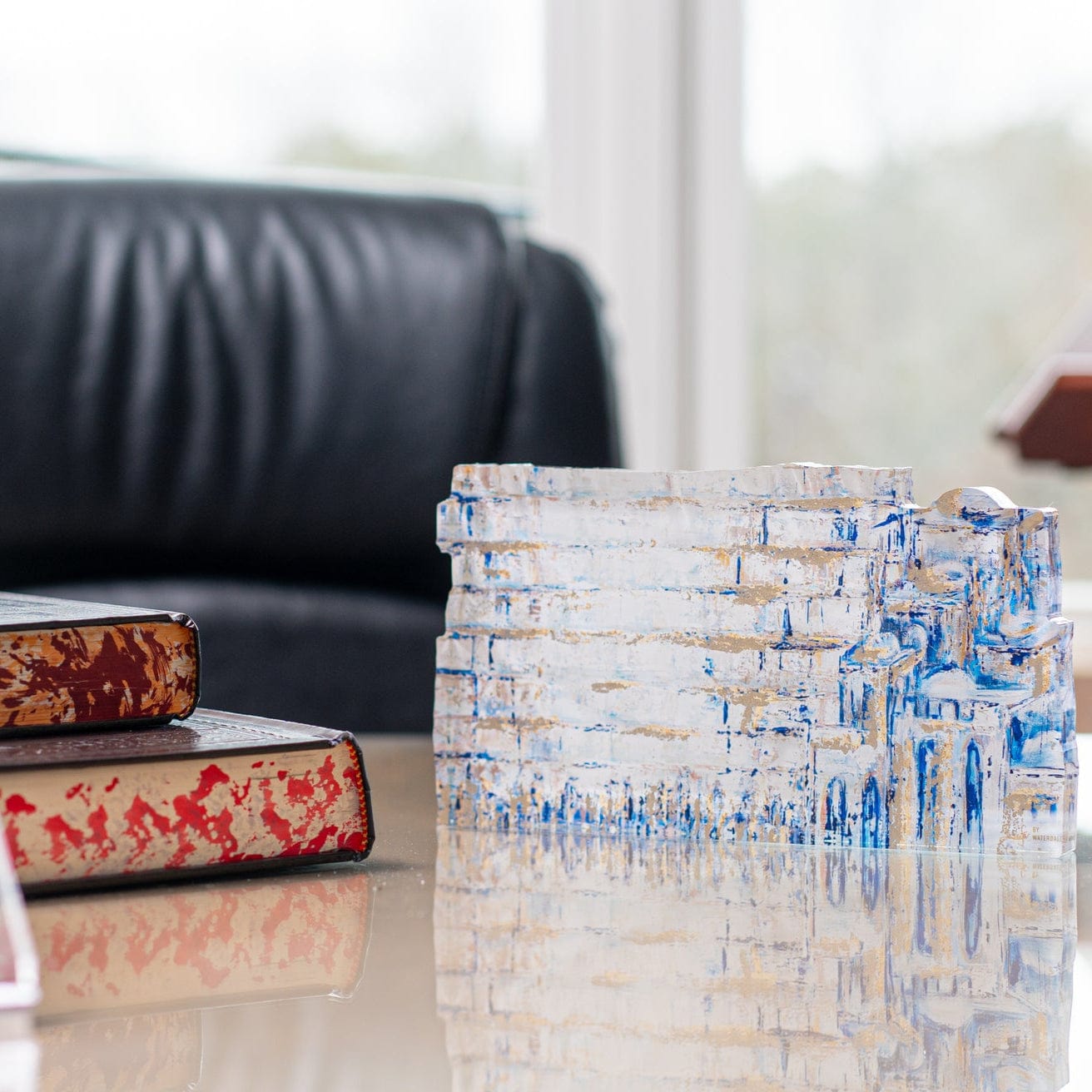 Painted Yosefa Kosel Sculpture on top of an office desk beside books | Waterdale collection