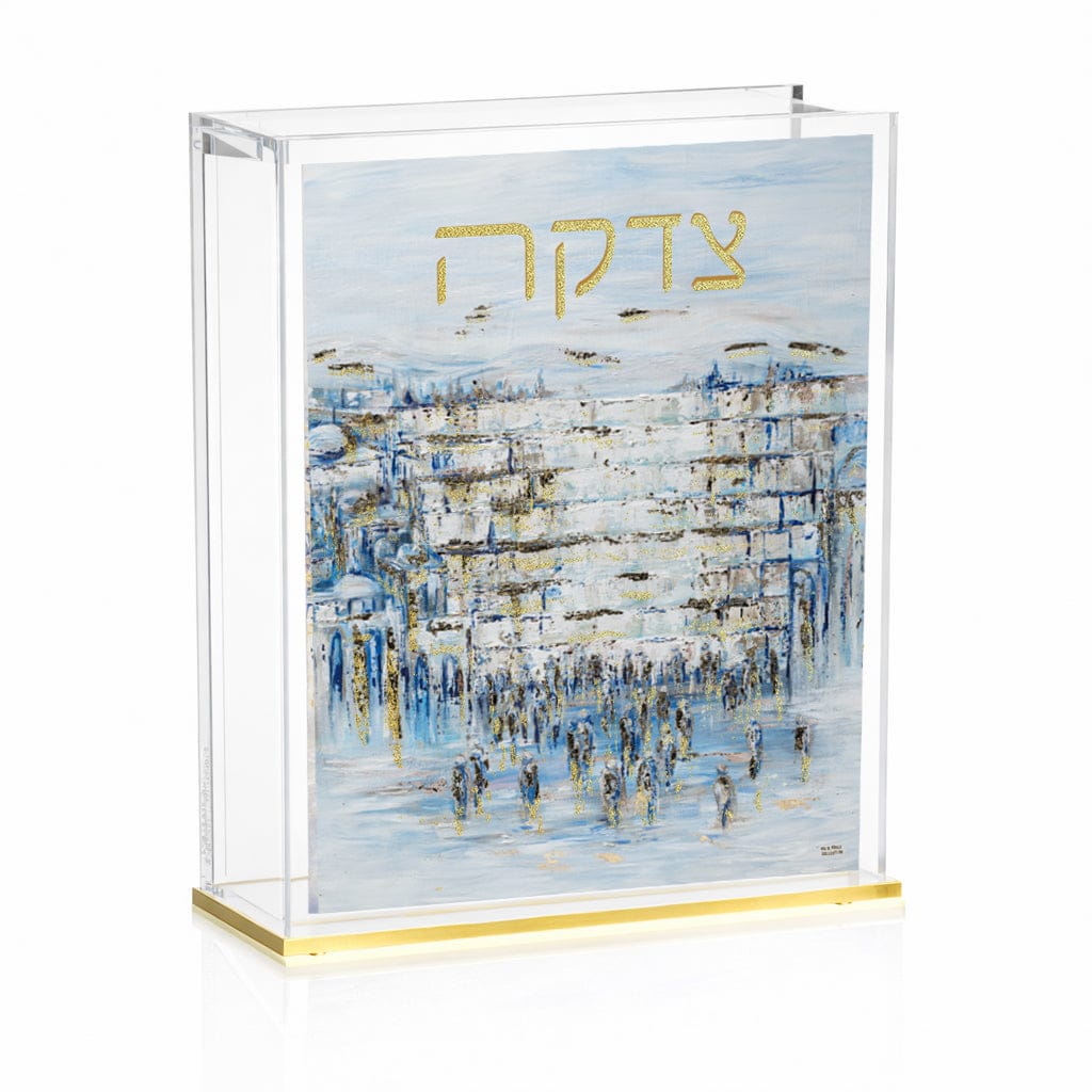 Painted Yosefa Kosel Tzedakah Box featuring a serene blue-toned painting of the Kosel with gold “Tzedakah” lettering, encased in a clear lucite box with a sleek gold base.