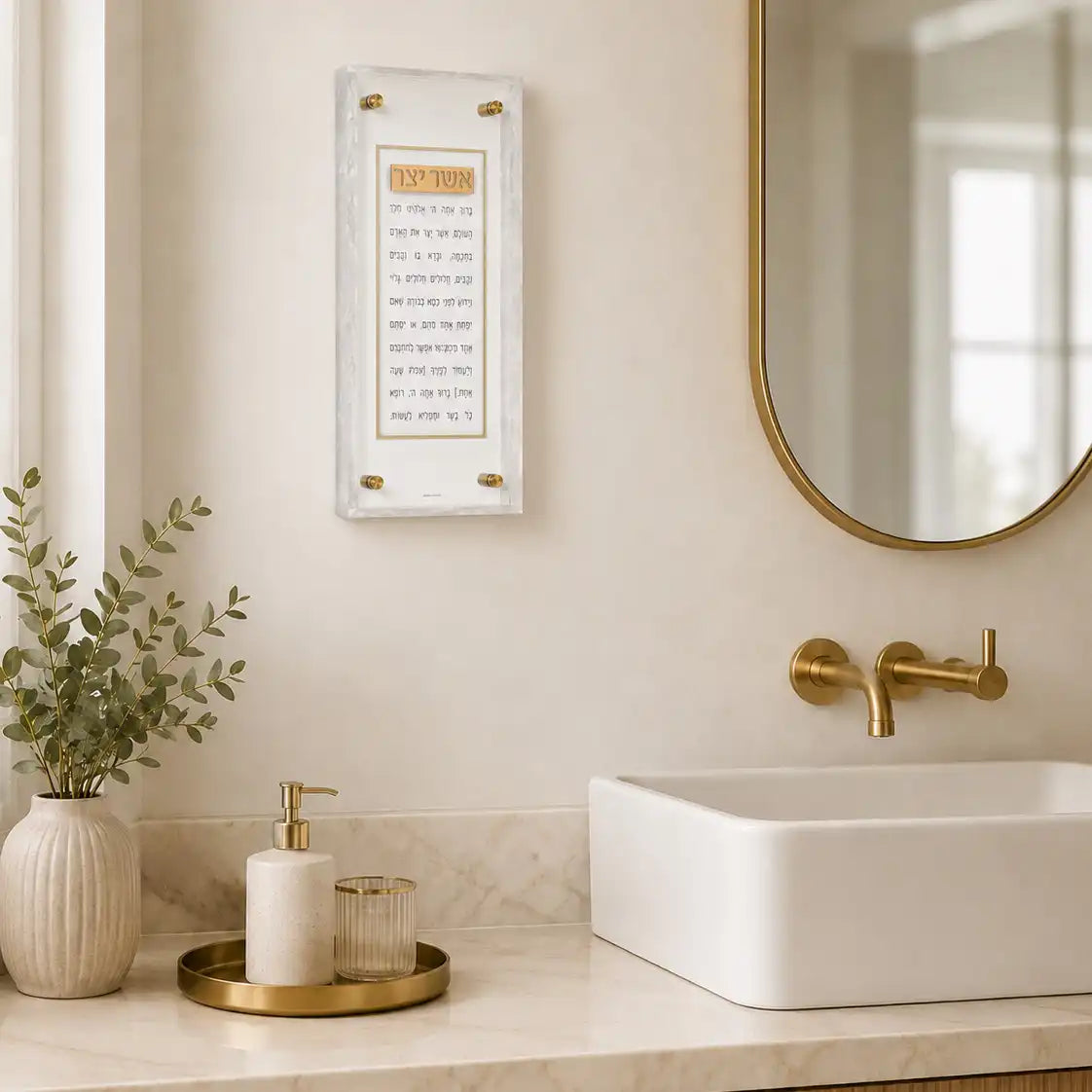 Pearlstone Frame Asher Yatzar Gold on the wall over a sink. Pearl marble design framed around a clear lucite base with white in the middle that features gold Asher Yatzar words.