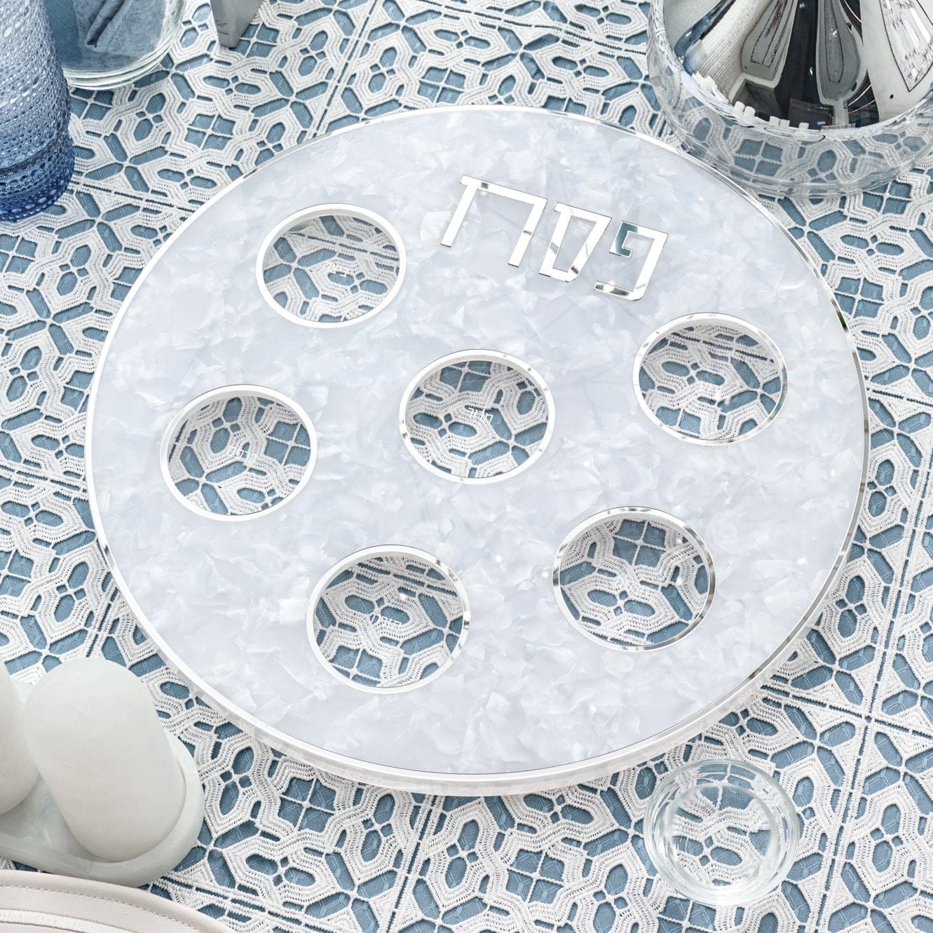 Pearlstone Seder Plate with white marble-look resin finish, six clear acrylic bowls, silver-rimmed edges, in a Seder table.