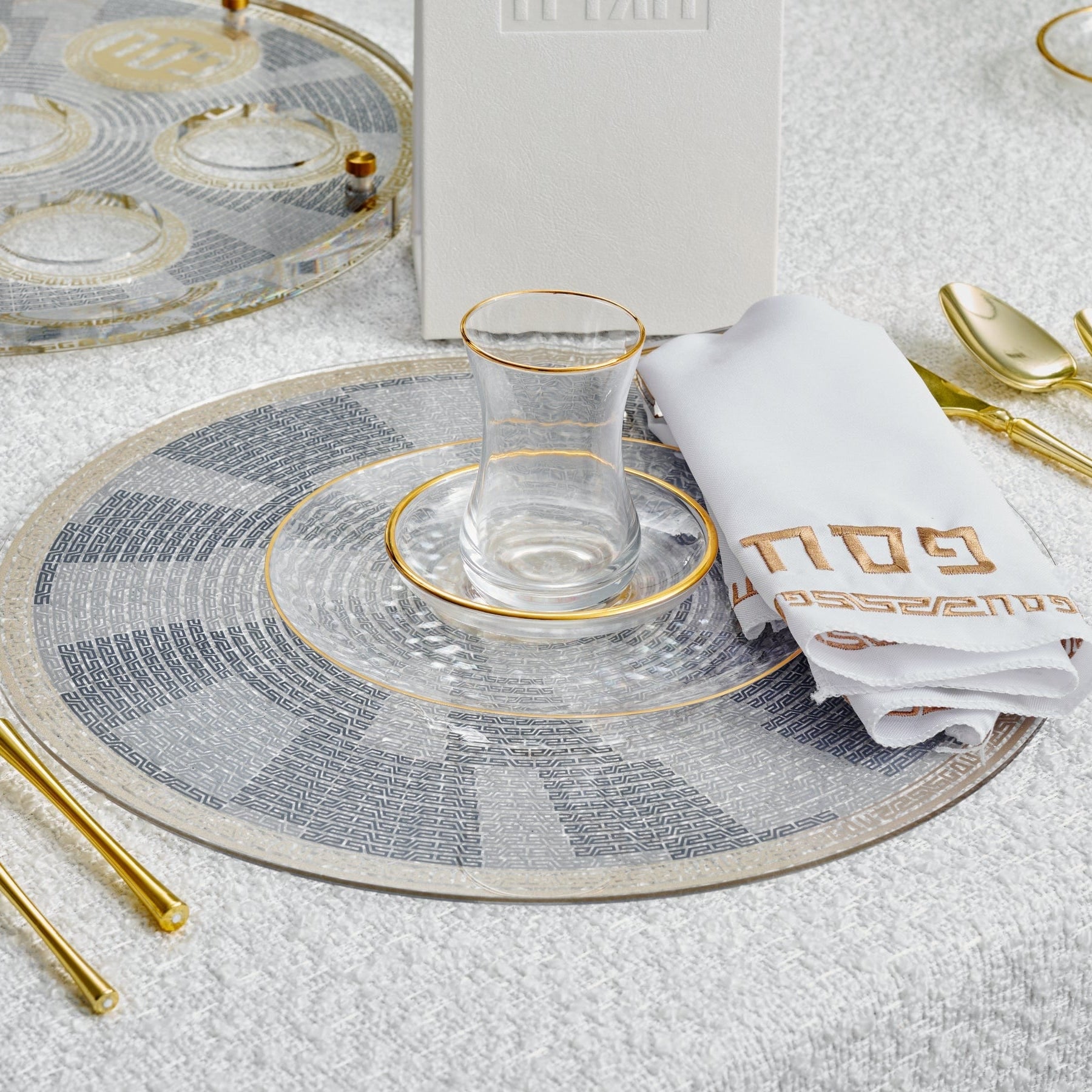 Gold Accent Pesach Geometric Chargers paired with elegant glassware and napkin on a white table setting | Waterdale Collection