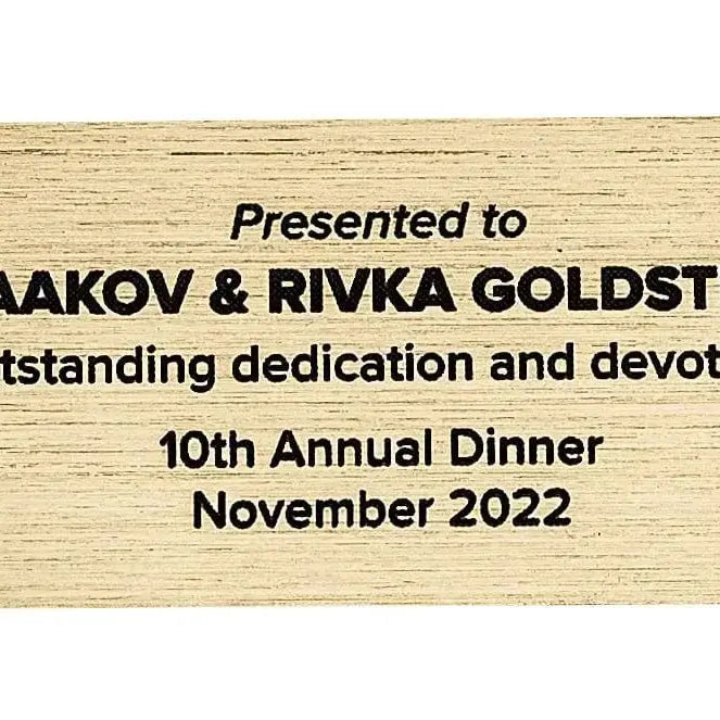 Purim Box Personalization hardware plaque in gold with black engraved text honoring Yaakov and Rivka Goldstein