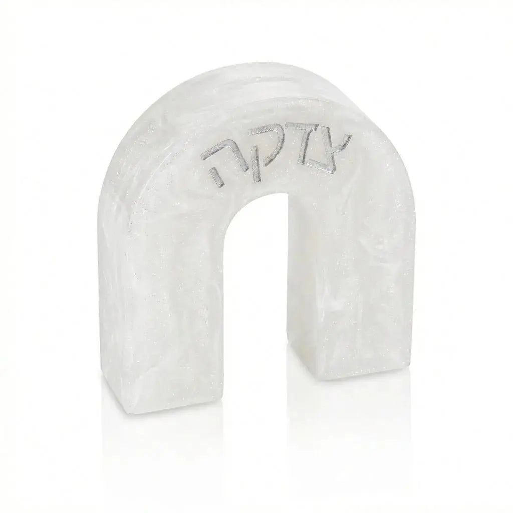 White resin arch-shaped tzedakah box with engraved text, featuring a modern curved design for Shabbat and holiday giving.