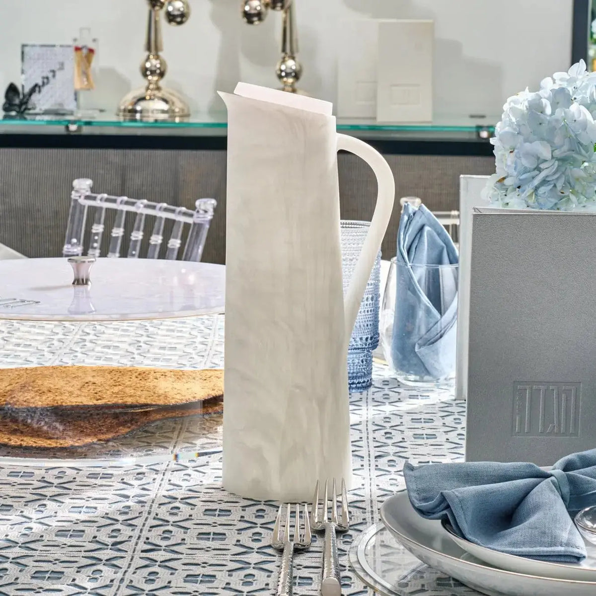 Cream resin pitcher by Waterdale Collection displayed on a patterned table runner with tableware and home décor.