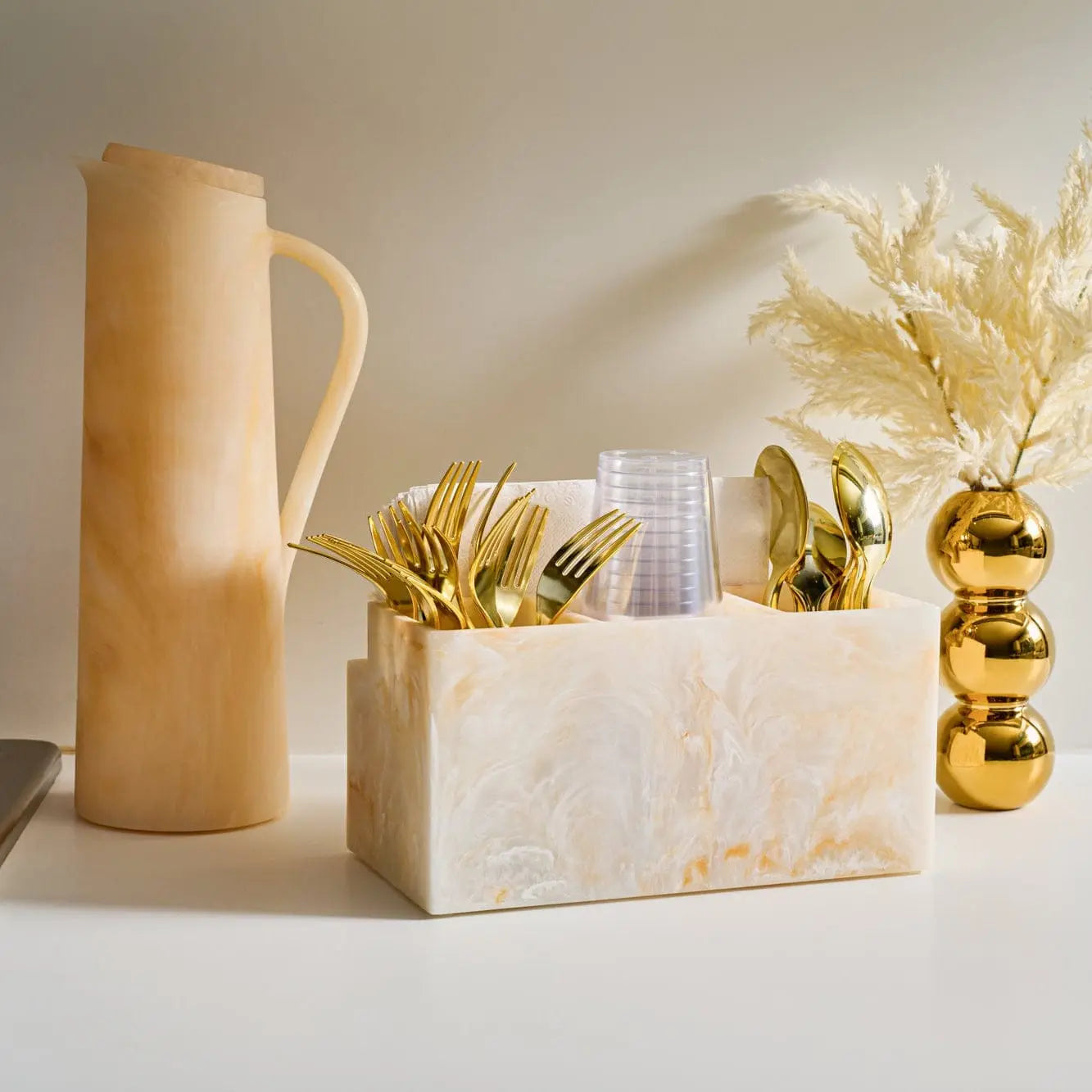 Beige resin pitcher styled with matching resin utensil holder and table décor – Waterdale Collection